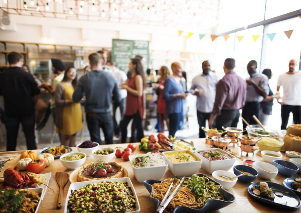 Buffet table full of diverse dishes at a casual event, highlighting budget dining tips for eating well at fixed-price meals.