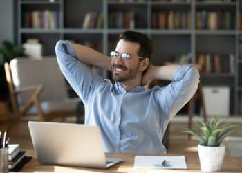 Smiling freelancer enjoying a relaxed moment at home office, showing the benefits of an organized daily routine freelancer lifestyle.