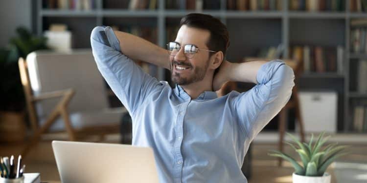 Smiling freelancer enjoying a relaxed moment at home office, showing the benefits of an organized daily routine freelancer lifestyle.