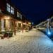 Snow-covered platform at a European train station at night with a modern night train ready for boarding — perfect scene capturing night train Europe travel.