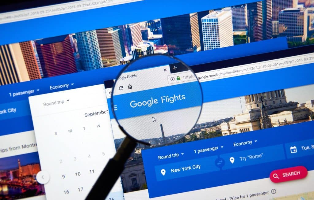 Magnifying glass highlighting Google Flights website, demonstrating practical tips for cheap flights and smart travel booking strategies.