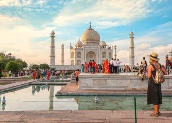 Travelers at the iconic Taj Mahal in Agra, a must-visit destination when you travel to India, with crowds and vibrant local culture on a bright day.