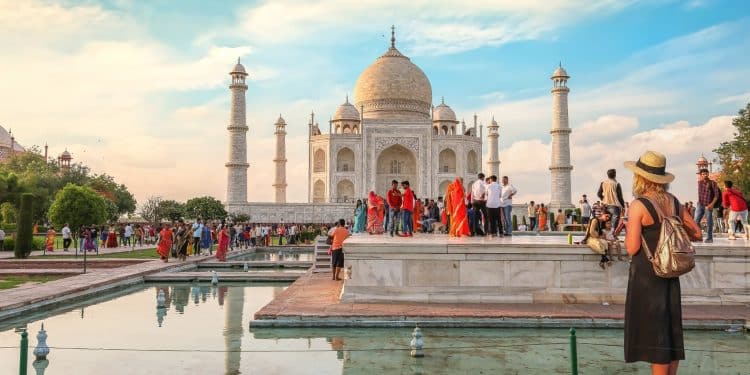 Travelers at the iconic Taj Mahal in Agra, a must-visit destination when you travel to India, with crowds and vibrant local culture on a bright day.