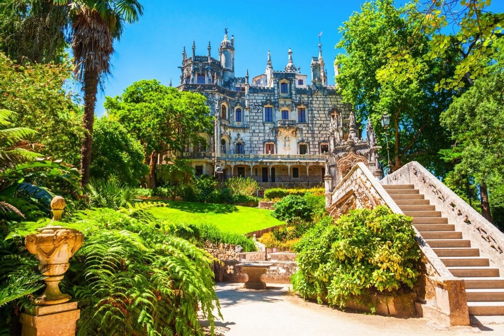 Majestic view of Quinta da Regaleira in Sintra, surrounded by lush gardens and historic architecture, highlighting why Sintra is among the best cities in Portugal.