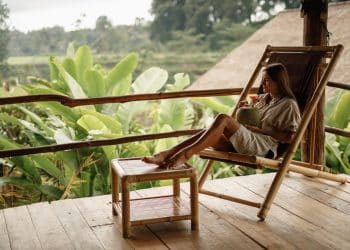 Woman enjoying a peaceful tropical view while sipping coconut water—one of the most peaceful places to visit.