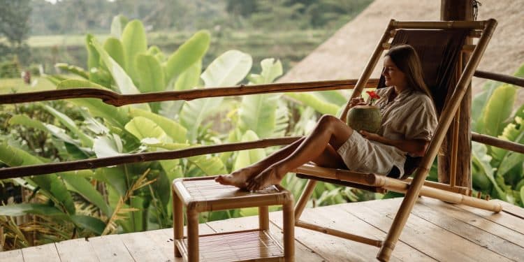 Woman enjoying a peaceful tropical view while sipping coconut water—one of the most peaceful places to visit.
