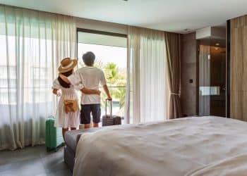 Couple arriving at a vacation rental found through Airbnb alternatives, enjoying the view from their short-term apartment.