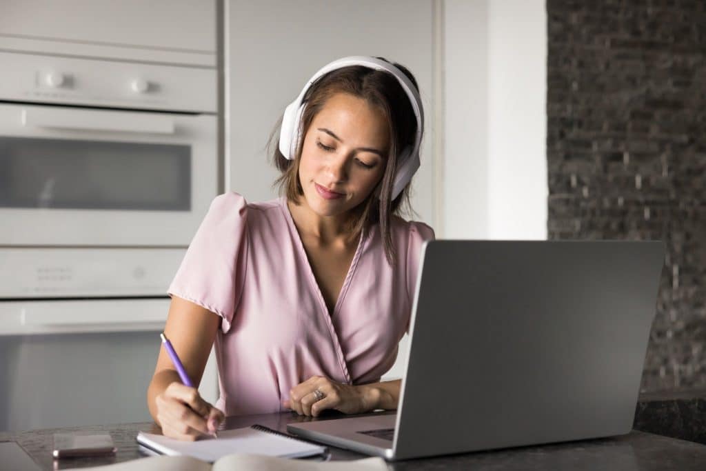 Remote worker using a laptop in a kitchen, staying in a rental booked through Airbnb alternatives for a flexible work trip.