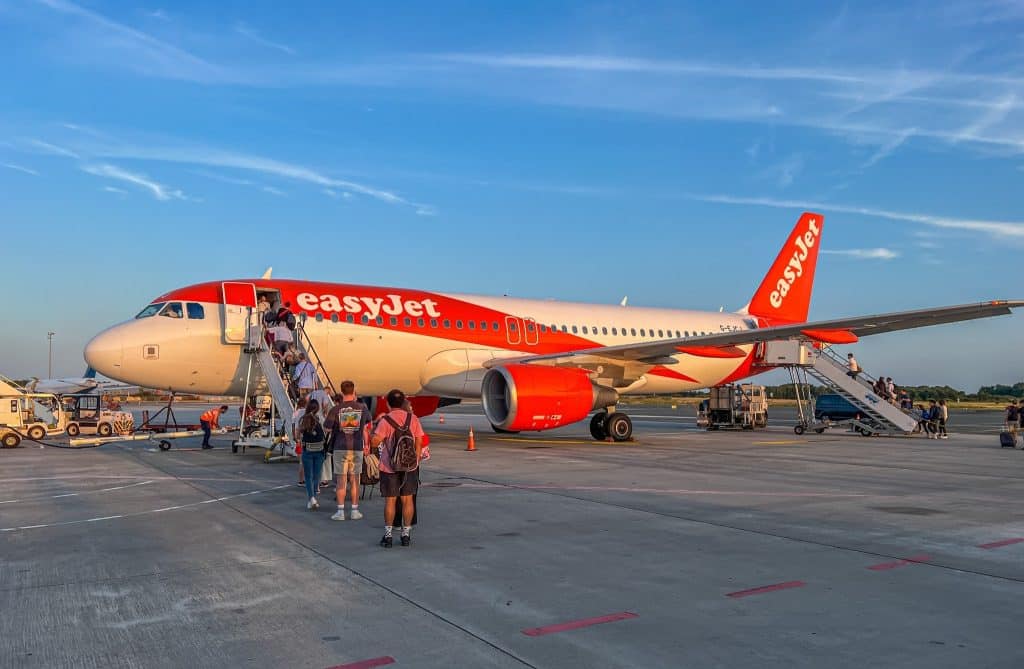 Travelers walking toward an easyJet aircraft, a popular choice among the best budget airlines 2025 for low-cost European flights.