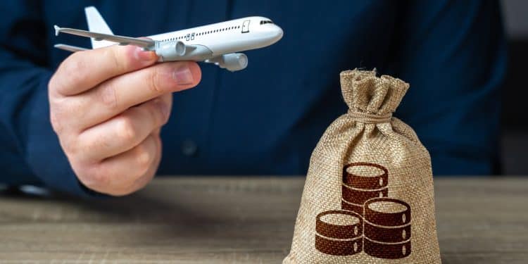 Traveler holding airplane model and money bag symbolizing savings with best travel loyalty programs.