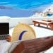 Traveler with a laptop on a sunny terrace overlooking the sea, capturing the lifestyle flexibility that comes with working abroad.