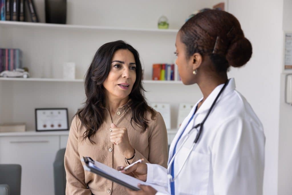 Doctor talking with a traveler about health coverage under digital nomad insurance.