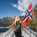 Traveler on a boat admiring the mountains in Norway, the perfect start to a guide to Norway fjords.
