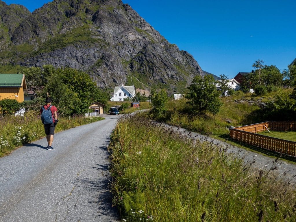 Backpacker walking through a quiet fjord village in Norway, a hidden corner highlighted in a guide to Norway fjords.