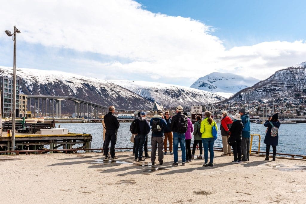 Group of travelers enjoying snowy mountain views along a fjord, capturing the spirit of a guide to Norway fjords.