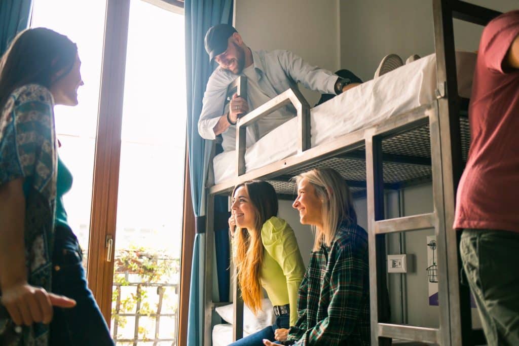 Group of students in hostel common room enjoying affordable stay with a student travel discount.