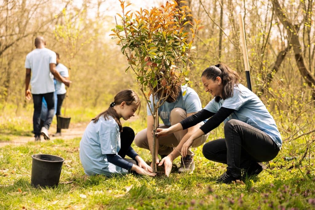 Family planting trees through eco-friendly volunteer travel programs.