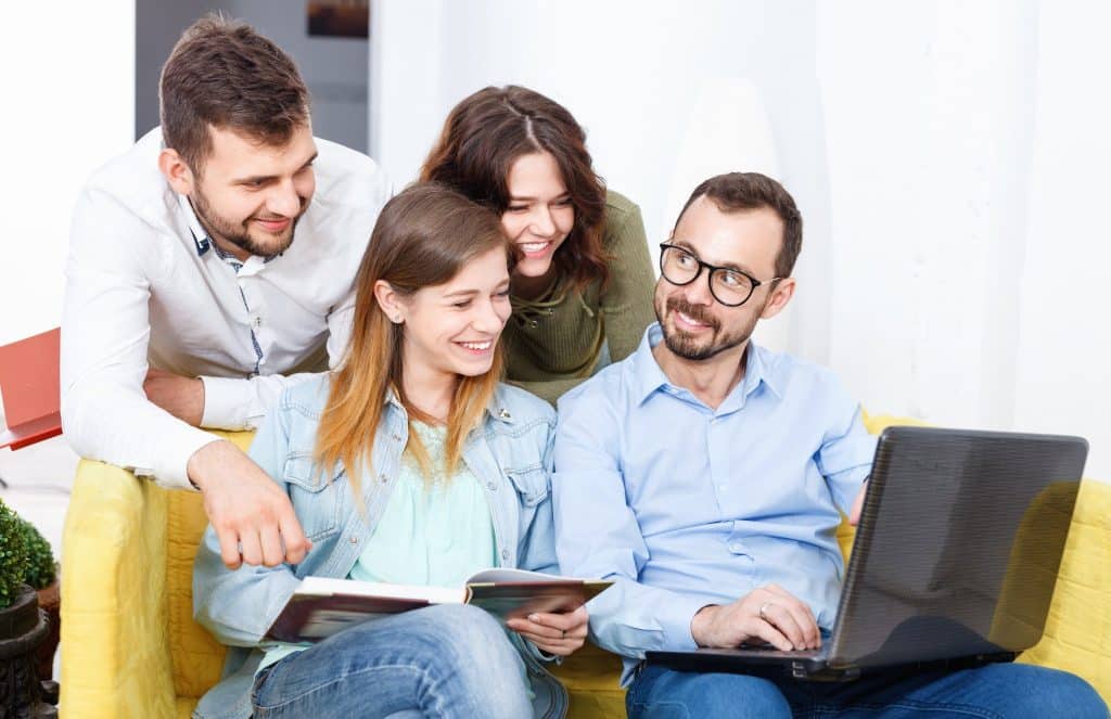 Friends smiling while booking cheap hotel online.