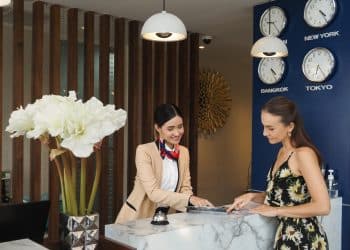 Guest at reception desk after booking cheap hotel stay