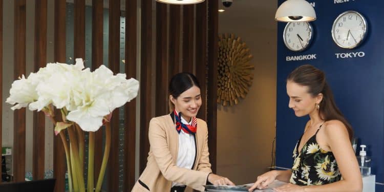 Guest at reception desk after booking cheap hotel stay