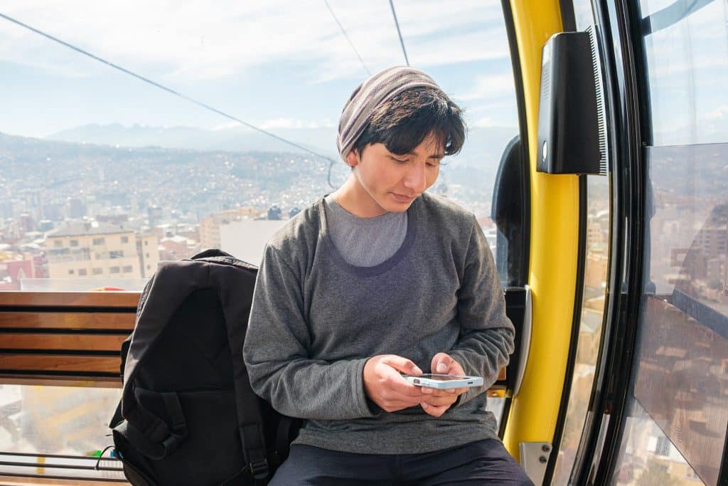Young traveler in La Paz cable car during budget trip