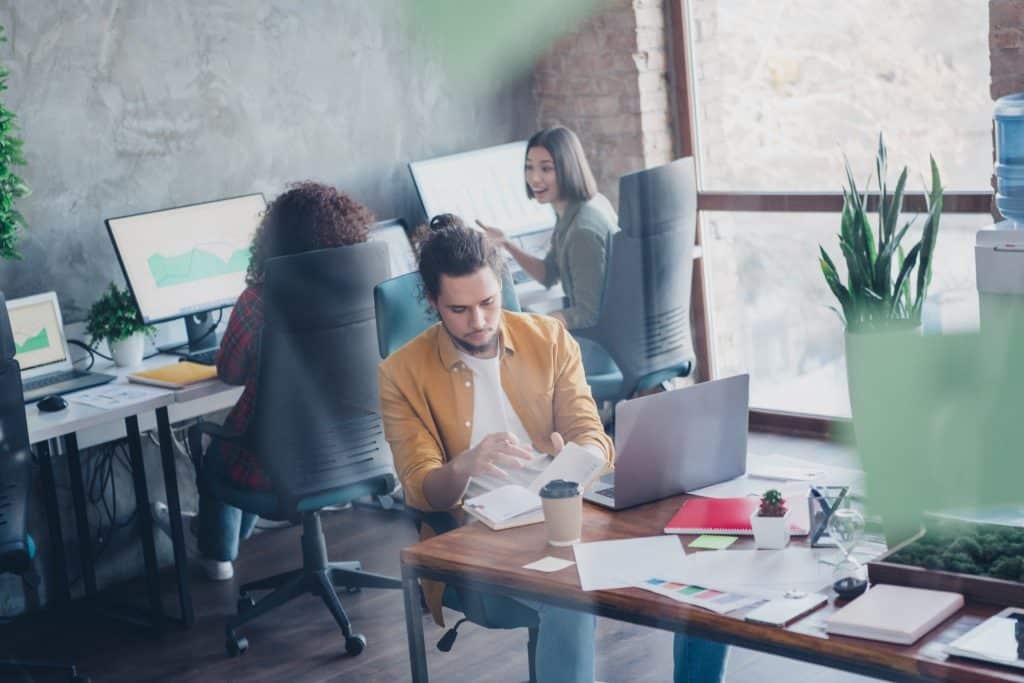 remote workers collaborating in coworking space, coliving for digital nomads