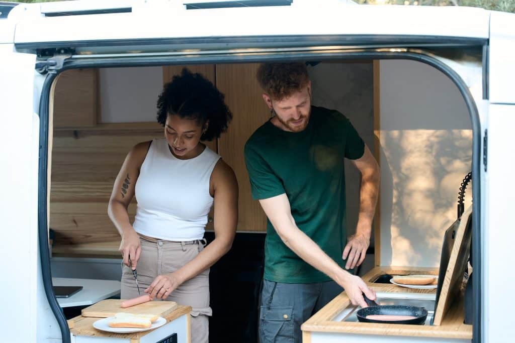 nomads cooking together in shared kitchen while traveling.