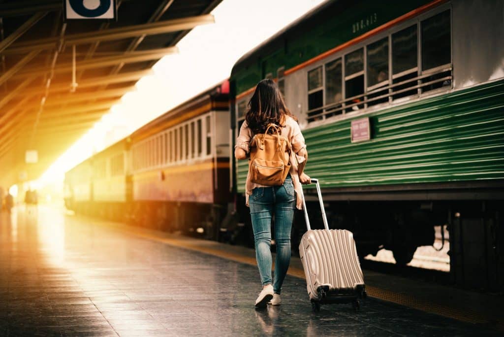Backpacker walking with suitcase at train station