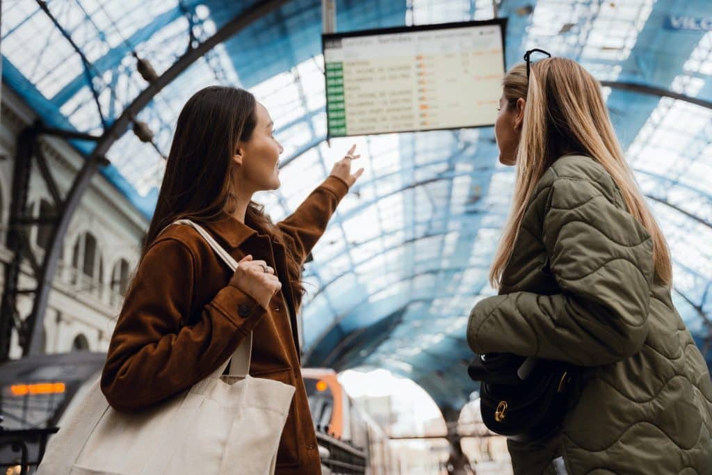 Friends checking departures board in European train station