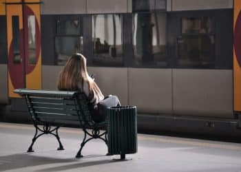 Passenger sitting on bench waiting for train