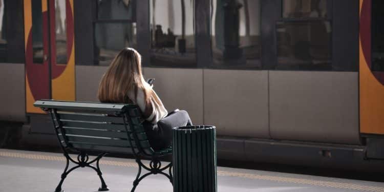 Passenger sitting on bench waiting for train