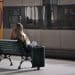 Passenger sitting on bench waiting for train
