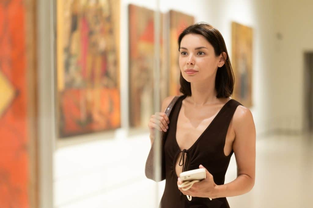 Woman looking at paintings inside a museum gallery