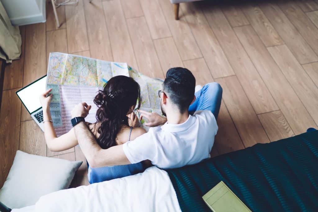 Couple planning trip with map and laptop using ITA Matrix routing language