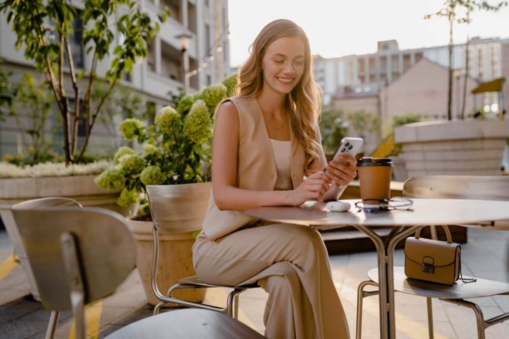 Woman using phone while planning flights with ITA Matrix routing language
