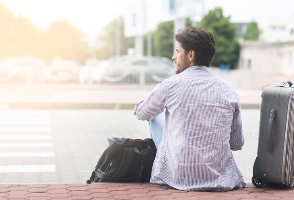 Traveler with suitcase waiting near airport at layover