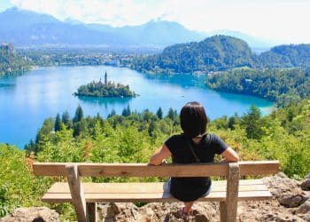 Traveler admiring Lake Bled travel with island in the distance.