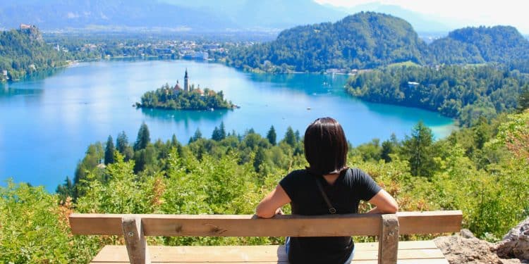 Traveler admiring Lake Bled travel with island in the distance.