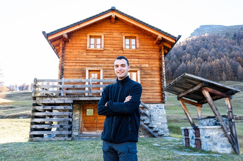 hiker standing outside mountain hut base village