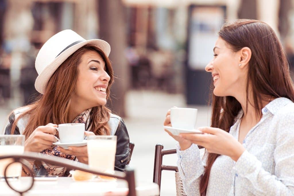 smiling expats networking at on outdoor cafe in Lisbon with portugal digital nomad visa 2025