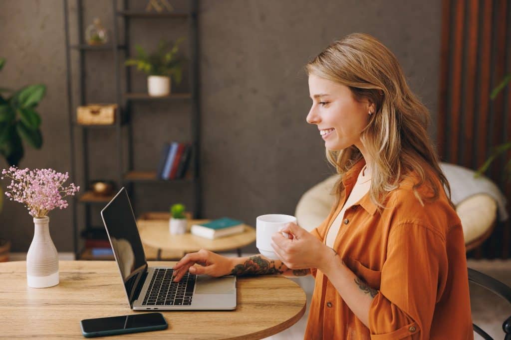 Traveler working on laptop in hostel lounge for remote office in a hostel