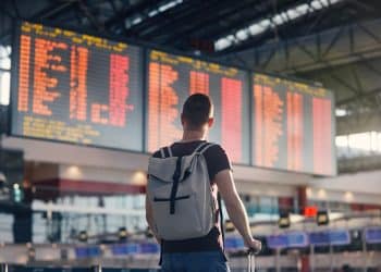 Traveler checking departures board during self transfer flights