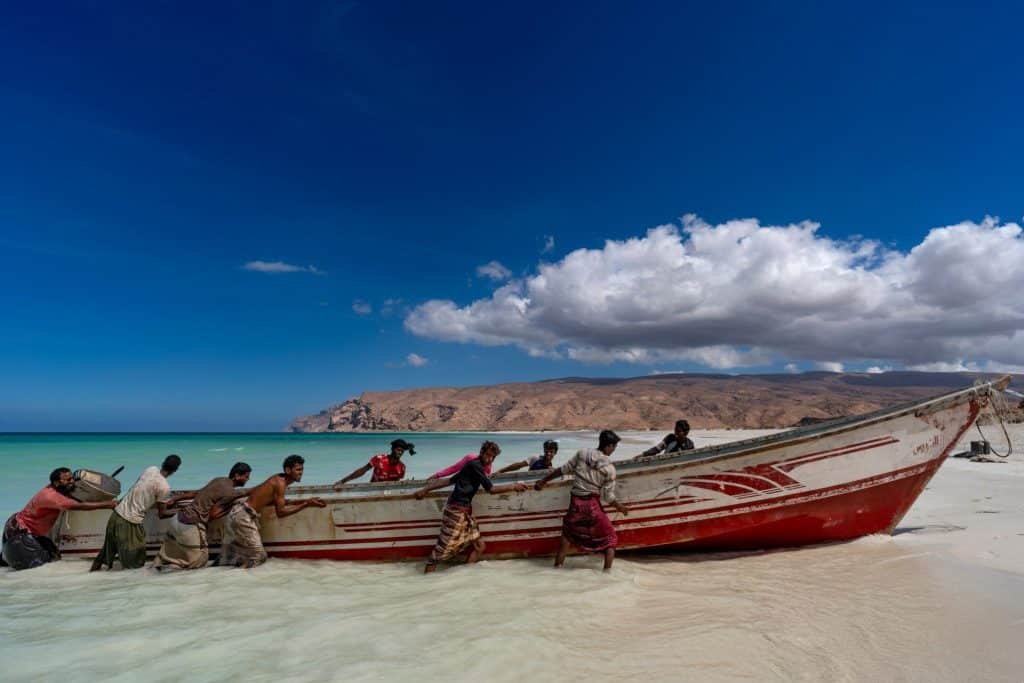 Locals on Socotra pushing fishing boat to shore
