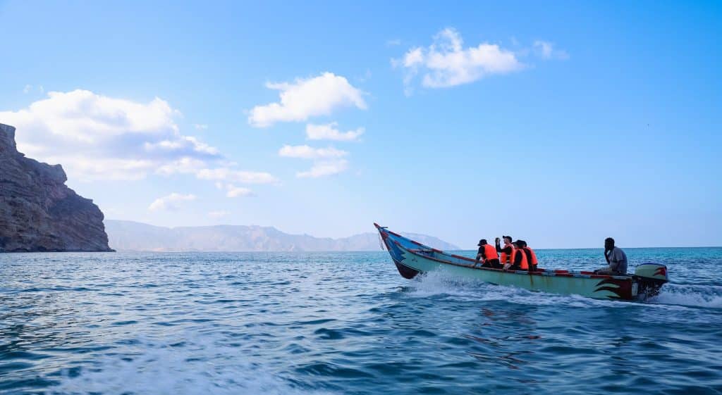 Tourists in boat exploring Socotra travel guide coast