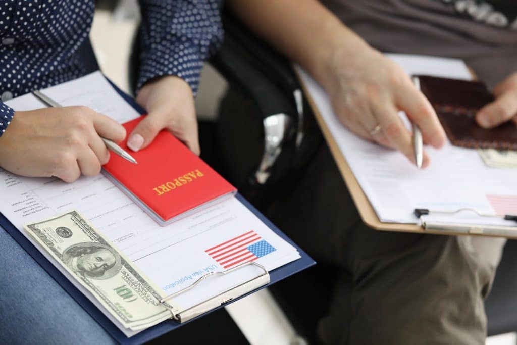 Traveler filling visa application with passport and money