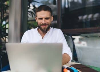 Man working remotely on laptop at outdoor café