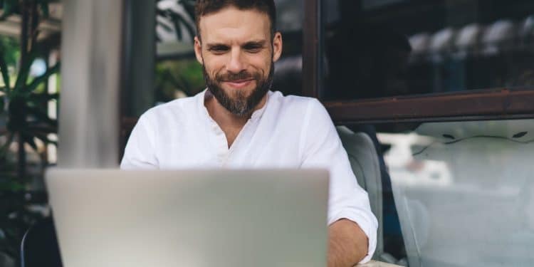 Man working remotely on laptop at outdoor café