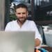 Man working remotely on laptop at outdoor café
