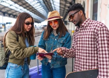 Travelers checking tickets at train station