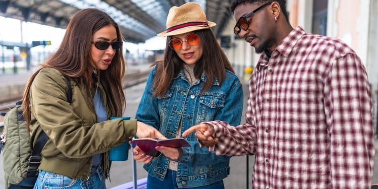 Travelers checking tickets at train station